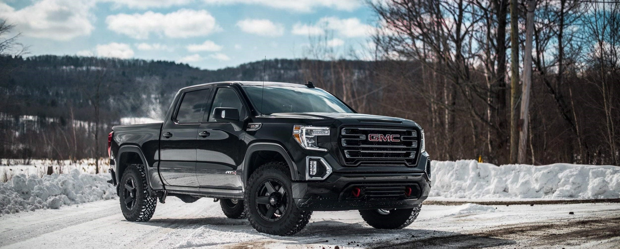 Black GMC Sierra crew cab parked on a snow-covered road
